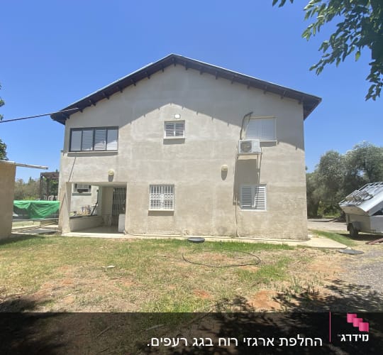 גג משופע עם רעפים כהים על בית דו קומתי